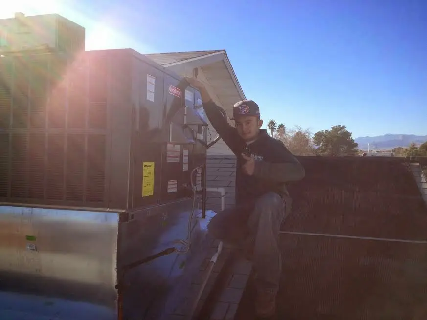 HVAC technician performing HVAC Inspection on a rooftop unit in Grambling